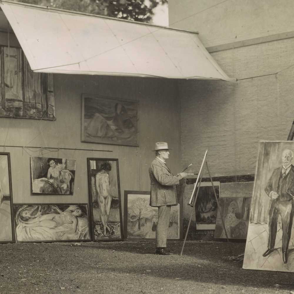 Edvard Munch står og maler i sitt friluftsatelier på Ekely. Han er omgitt av sine egne verk og har på seg en hatt som skygger for solen og en lys dress.