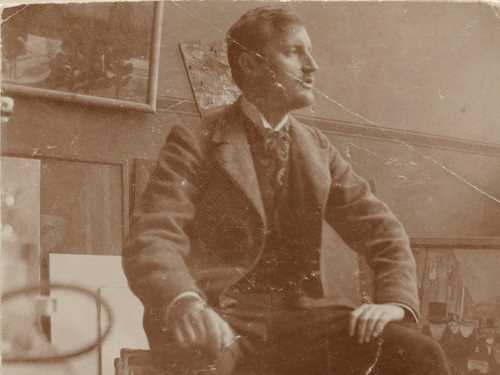 Edvard Munch: Edvard Munch på sin reisekoffert i atelieret i Lützowstrasse 82 I. Fotografi, 1902. Foto © Munchmuseet