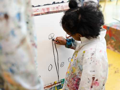 Barn som tegner på lerrett staffeli