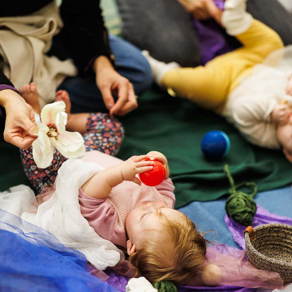 Baby leker med liten ball.