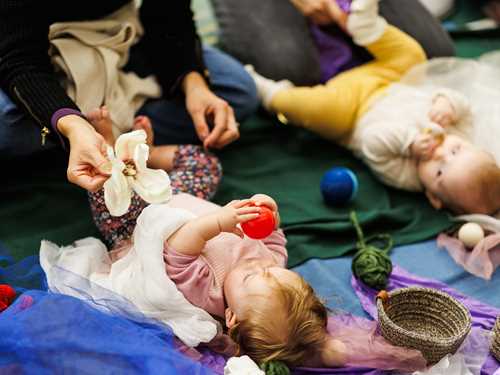 Baby leker med liten ball.