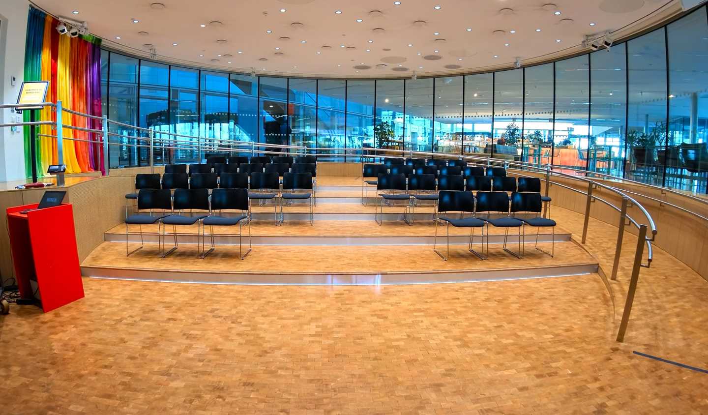 Amfi-salen på MUNCH. Et rundt rom med vinduer rundt hele rommet. I midten av rommet er det fire stolrader. Fotografi