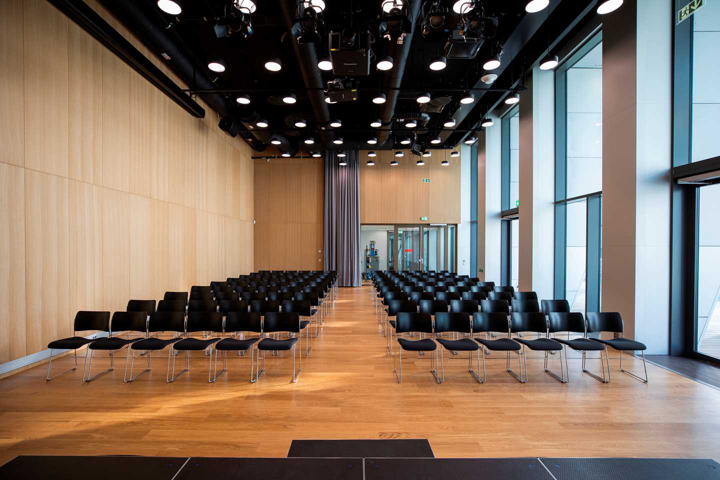 MUNCHs toppsal sett fra scenen. Et avlangt rom med mange rader med svarte stoler. Fotografi