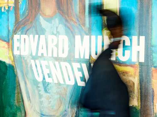 En person går forbi skiltet ved inngangen til utstillingen Uendelig på MUNCH. Fotografi