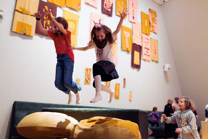 Kids playing in The Chamber of Chaos, a wonderful world of portals, colourful pillows and textile figures, surrounded by magical lighting