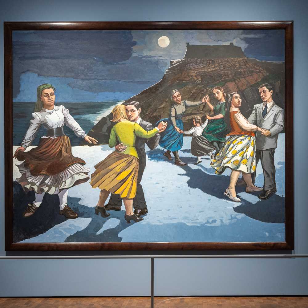 En mann står med ryggen mot kamera og betrakter verket Dansen av Paula Rego. Maleriet viser en strand med et fjell i bakgrunnen og en mørk himmel med en lysende måne. På stranden er det flere par som danser og en kvinne som danser alene. Fotografi